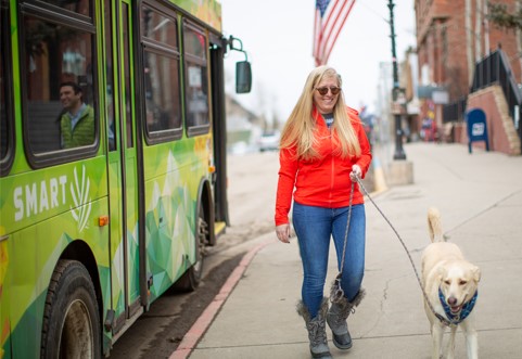 Woman Walking Dog after getting off the Bus